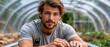 © Soba - Male gardener leaning on metal rails inside greenhouse tunnel