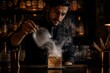 © mila103 - Mixologist unveiling smoky cocktail on bar counter at night