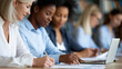 © Nataliya - Anonymous group of diverse female legal professionals gathered around a conference table reviewing case files, women in law and corporate teamwork concept, faceless, defocused