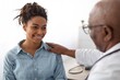 © Prostock-studio - Smiling Young Black Woman Engaging With Doctor During Consultation At Clinic Office, Showing Positivity And Comfort. Professional Interaction Demonstrating Trust In Healthcare Setting.
