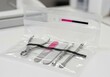 © Tiana_Geo - Sterilized manicure instrument kit in sealed plastic pouch. Professional metal tools for nail care and pedicure maintenance. Sanitation and hygiene medical supply in beauty salon.
