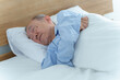 © taka - ベッドで眠る高齢者の男性