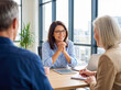 © One-Studio - Mature financial advisor discusses future investment plans with senior couple in a modern office setting.