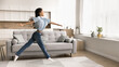 © fizkes - Beautiful preteen age girl having fun in cozy living room, spread her arms and legs while jumping, looks like ballerina, rehearsing, performing dance enjoy active carefree leisure alone at modern home
