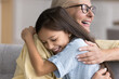 © fizkes - Close up pre-teen granddaughter and happy older grandma hugging tightly, express support and caress, feeling unconditional love, laughing, enjoying family reunion, strong, harmonic relationships. Bond