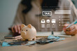 © MarkFinal - Piggy bank with cash and credit card on desk during annual tax planning