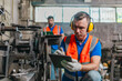 © SpaceOak - Factory Technicians Reviewing Machine Maintenance Checklist in Metal Workshop