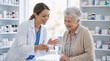 © ideas - Professional female pharmacist in white coat explaining prescription medication to a senior woman patient at pharmacy counter