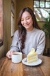 © Farknot Architect - Vertical portrait image of a woman drinking coffee and eating a lemon cake in cafe
