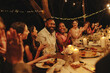 © Jacob Lund - Guests joyfully celebrate at an intimate evening wedding reception outdoors