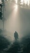 © rabbit75_fot - Outdoor adventure explore. A moody, atmospheric portrayal of a solitary figure walking through a dense forest shrouded in mist. The figure, dressed in dark clothing, walks away from the viewer.