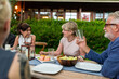 © Rawpixel.com - Smiling diverse adults enjoying an outdoor dinner conversation together