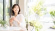© ratesuke - カフェのテラス席で寛ぐ笑顔の女性