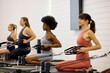 © Guille Faingold/Stocksy - Four women engage in a pilates class inside a fitness studio