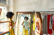 © Guille Faingold/Stocksy - Two Women Trying on Clothes in a Store