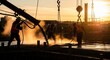 © Nanang - Construction Crew Pours Concrete At Sunset With Dust And Steam Rising