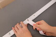 © Imageologist - Hands tightening a white nylon anchor strap on a bed rail stabilizer bar.