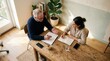 © RIOKO - Collaborative Meeting Session At Wooden Table With Documents And Coffee