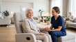 © Iuliia - Nurse kindly holding hand of elderly woman sitting in armchair at home. Professional caregiver supporting retired patient. Compassionate medical assistance and healthcare service concept.