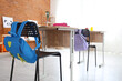 © Pixel-Shot - Blue backpack on chair in classroom, closeup