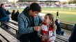 © Shahid  - Happy Teenager and Little Sister Watching Football Match in Stadium Stands, Older Brother Explaining Soccer Game to Child, Emotional Supporters bonding with Matchday Program and Scarf, Stock Photo