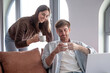 © luciano - Happy couple relaxing at home, drinking coffee while man is working on laptop, lifestyle and remote work