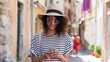 © Mary - Young woman using smartphone on colorful city street