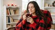 © Николай Срибяник - Young woman drinking hot mulled wine in a cozy living room at home.