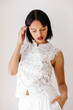 © Tania Cervian/Stocksy - Woman wearing white lace cheongsam style top