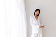 © Tania Cervian/Stocksy - Woman next white curtain smiling