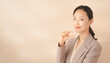 © noonekoon - Professional Woman Showing Product Information もう少しのジェスチャーをするベージュのスーツを着た女性