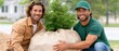 © lililia - Workers moving large tree for landscape installation, professional teamwork, outdoor development, environmental improvement project.