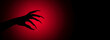 © cato_rium - Monster hand with long claws reaching out of dark red background. Scary gesture expressing fear or horror for Halloween banner concept with copy space for movie or cinematic poster.