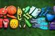© New Africa - Different sports equipment, bottle and headphones on green grass, flat lay