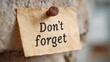 © Ruzana - Vintage reminder note pinned to rustic wall with thumbtack for memory aid and motivation