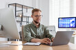 © New Africa - Financial trading specialist working with laptop at wooden desk in office