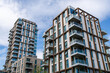 © MarshallChan - Modern residential apartment buildings with balconies under blue sky in urban setting