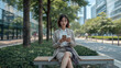 © bephoto - 昼の都市公園で休憩する日本人ビジネス女性の写真