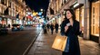 © Mark - Happy woman holding credit card and shopping bags on a city street at night