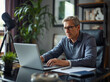 © Joji Watanabe - Serious businessman with grey hair in glasses using a laptop in a modern office, working on online trading and investment