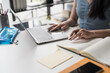 © Charlie's - Young Asian Woman Using Laptop for Work at Home on Modern Desk Setup in Cozy House