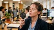 © Olga Ко - Exhausted sweating businesswoman finding relief from an extreme heatwave using a portable handheld fan at her office desk