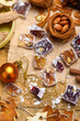© soleg - Scattered cubes of traditional Turkish delight with nuts on parchment paper among Christmas ornaments and dried citrus