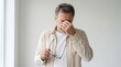 © Shiv - Middle aged man feeling tired and removing glasses to rub bridge of nose with headache exhausted eyestrain removing