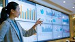 © TE - Business professional showcasing data analysis in a contemporary office setting with advanced digital screens