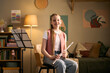 © DragonImages - Portrait of Caucasian girl studying music and holding flute during home practice, representing arts education and skill development. Useful for music lessons, tutoring, youth learning