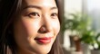 © Platon - Close-up portrait of a happy Asian woman smiling in the bright morning sunlight. Her face is beautifully lit, showing glowing skin and bright brown eyes