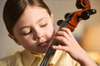 © DragonImages - Close up of Caucasian girl practicing cello, studying music with focused hand placement and skill building. Useful for music education, lessons, youth talent promotion