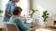 © Erika - Elderly woman sitting in living room using tablet with floating health icons while nurse stands nearby