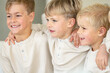 © Austockphoto - Young boys sitting on the couch with arms over each others shoulder